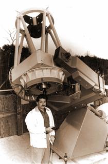 Tim Puckett standing beside his hand-built telescope